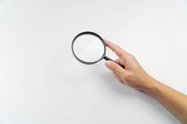 istock Woman Hand Holding a Magnifying Glass on White Background 2198656919