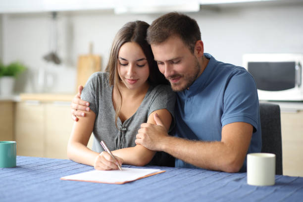 istock Interracial couple signing contract in the kitchen 2198660872