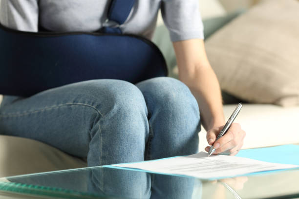 Convalescent woman signing insurance contract at home stock photo