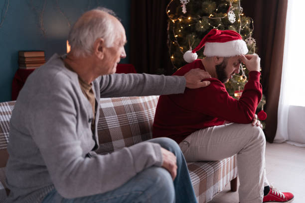istock Old father asks for forgiveness calms his son sitting on the sofa ignoring him 2198662139