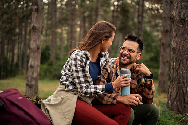istock Young couple having fun in the forrest while having rest from hiking 2198667990