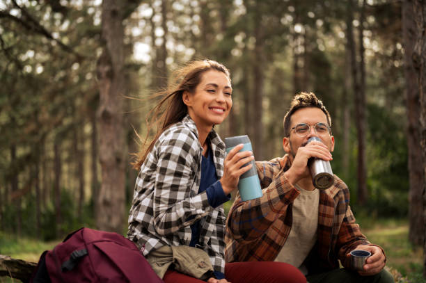 istock Young couple having fun in the forrest while having rest from hiking 2198668032