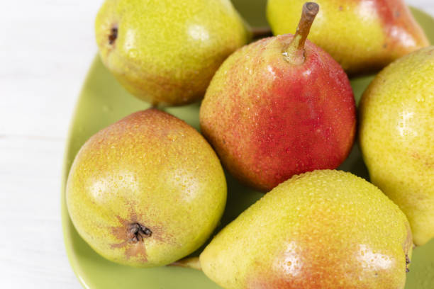 istock Ripe pears with water drops on green plate 2198668841
