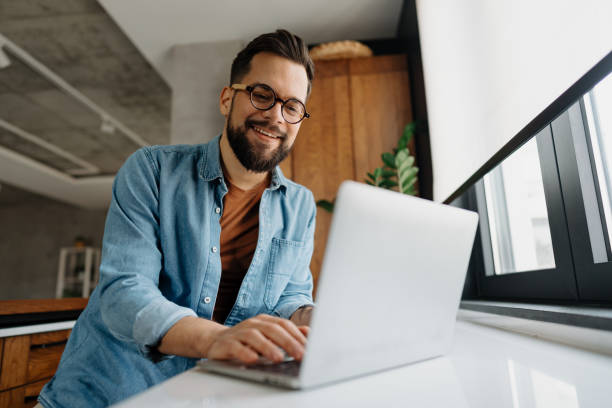 istock Freelancer working from home typing on laptop and smiling 2198671410