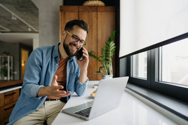 istock Freelancer talking on phone and working on laptop at home office 2198671922