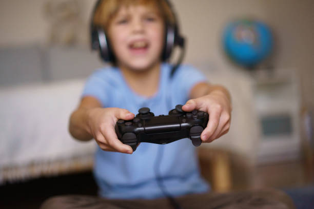 istock A boy is holding a joystick while playing games at home 2198671981