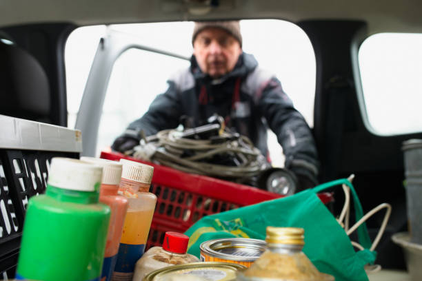 Senior man unloads recyclable materials at the recycling center