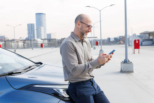 istock A man leaning on a car and using a phone 2198683432