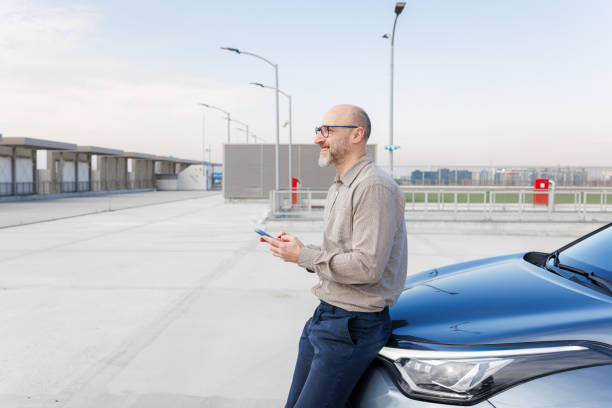 istock Mature businessman using phone next to his car 2198683509