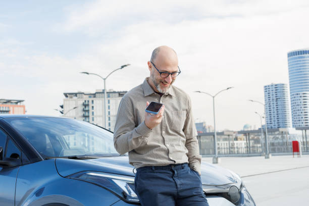 istock Businessman using a smart phone in the rooftop parking garage 2198683533