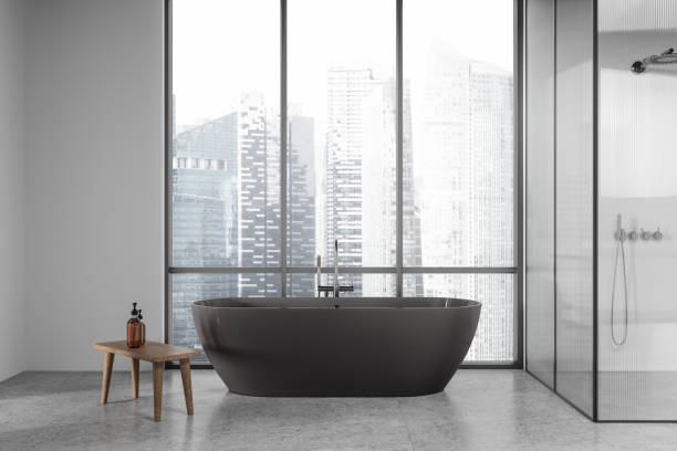 istock Bright modern bathroom with freestanding tub and city view through arched windows. 3D Rendering 2198684329