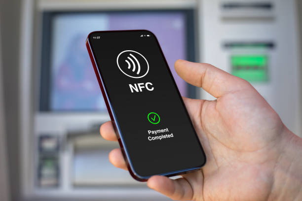 istock man hand phone pay wireless technology nfc via pos terminal 2198684443