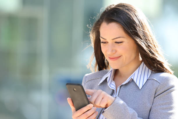 istock Satisfied executive checking smart phone in the street 2198684509