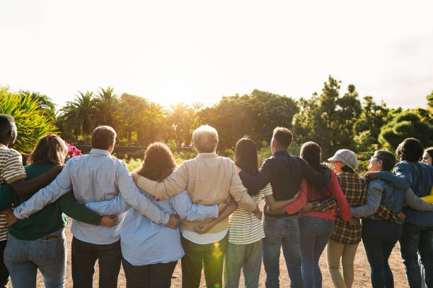 istock Group of multigenerational people hugging each others - Support, multiracial, empowering and diversity concept - Main focus on senior man with white hairs 2198684550