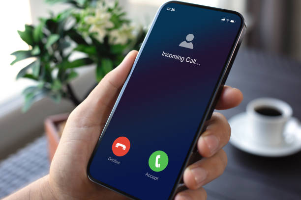 istock male hand holding phone with incoming call screen in office 2198684567