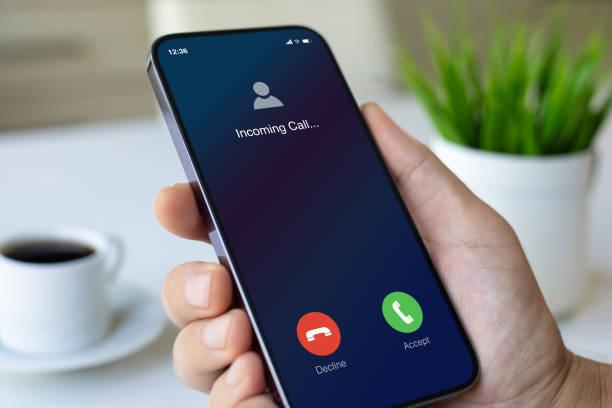 istock male hand holding phone with incoming call screen in office 2198684995