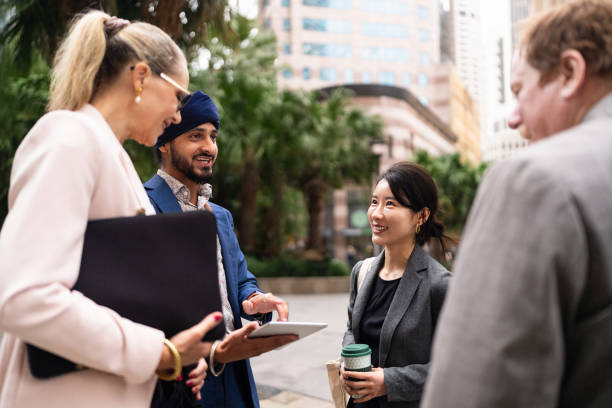 istock A multinational team of business professionals engaged in a discussion outdoors, using a digital tablet 2198685290