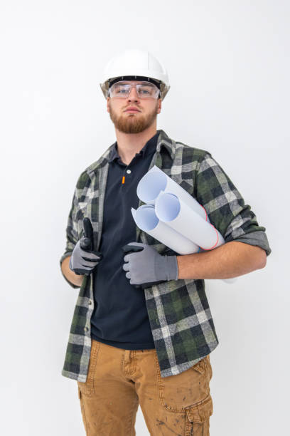 istock Male builder. Engineer in overalls and helmet holds blueprints and projects in his hands. 2198687590