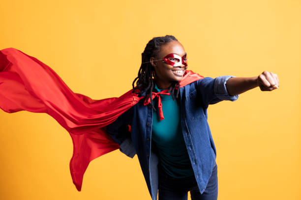 istock Superhero flies with cape fluttering in wind, hiding identity, studio background 2198688114