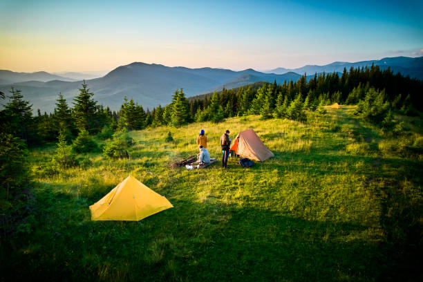 istock Two campers enjoying serene view of rolling mountains under clear sky. 2198688251