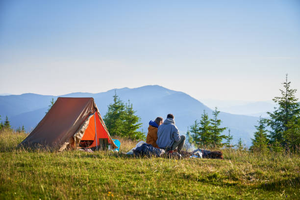 istock Two campers enjoying serene view of rolling mountains under clear sky. 2198688278