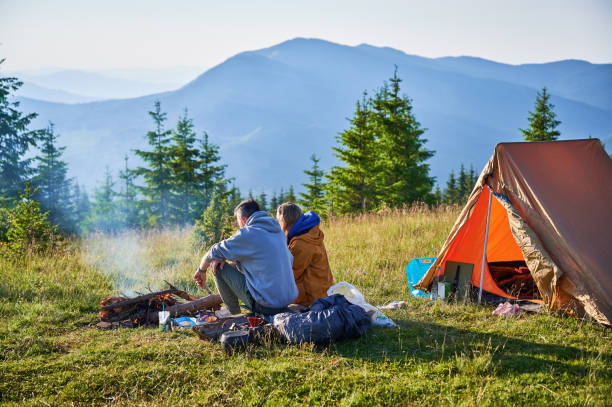 istock Two campers enjoying serene view of rolling mountains under clear sky. 2198688299