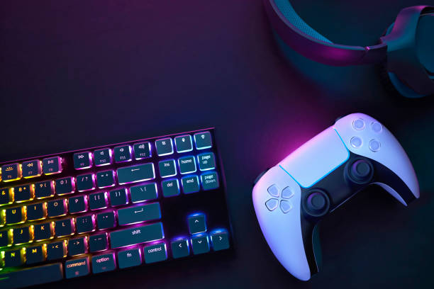 istock Top down view of colorful illuminated gaming accessories laying on table. 2198697661
