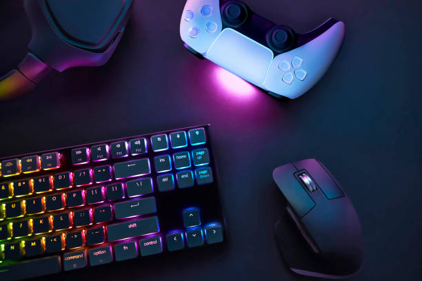 istock Top down view of various gaming accessories laying on table. Colorful illuminated devices. 2198697693