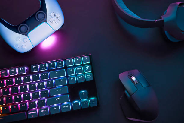 istock Top down view of various gaming accessories laying on table. Colorful illuminated devices. 2198699280
