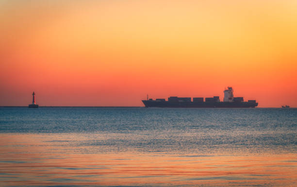 The cargo ship on the sea at sunrise