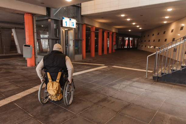 A handsome redhead wheelchair bound male commuter buying a ticket during a day trip in the Netherlands