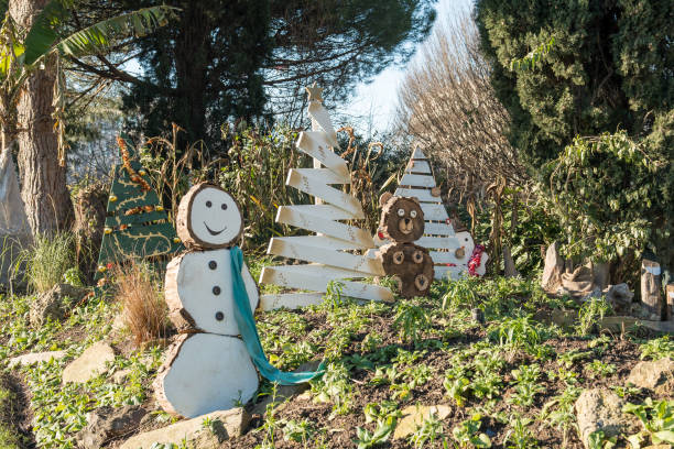 Paris,France-14.01.2025 A charming winter garden displays wooden snowmen and Christmas trees, basking in sunlight. This festive setup enhances the seasonal spirit with rustic decor.