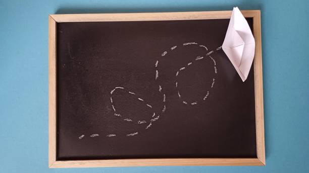 istock Black Chalkboard Dotted Chalk Path. Creative Idea. Toy ship made of paper. 2198702183