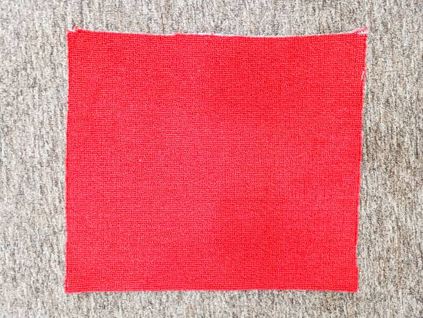 istock Close-up of a red carpet sample with a textured surface, placed on a contrasting beige carpet background in a Jakarta store. Ideal for showcasing fabric quality, texture details, and interior design materials 2198702913