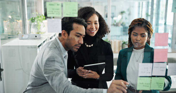 istock Teamwork, writing and business people on tablet in office for schedule, brainstorming and writing ideas. Sticky notes, corporate and workers on digital tech for planning, research and collaboration 2198703331