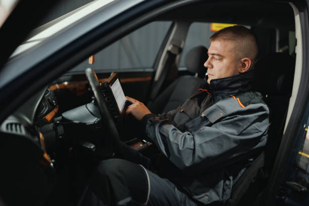 istock Car Mechanic Diagnosing Vehicle with Tablet 2198704093