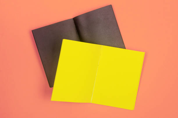 istock Blank black and yellow notebooks placed on a vibrant pastel backdrop, perfect for branding or creative mockups. 2198704634