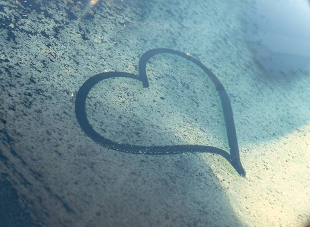 istock Valentine's Day concept: hand-drawn heart pattern on a frozen car windshield. Hand drawn heart shape on windshield of the car. Love symbol. 2198704649