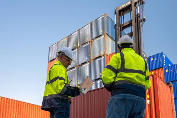 istock Dock worker overseeing operations logistics and shipping yard managing inventory, shipping schedules, or container tracking technology, and safety in the shipping industry, depicting a professional in action at a container yard. 2198707579