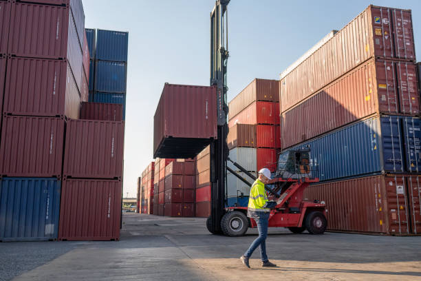 istock Dock worker overseeing operations logistics and shipping yard managing inventory, shipping schedules, or container tracking technology, and safety in the shipping industry, depicting a professional in action at a container yard. 2198707598