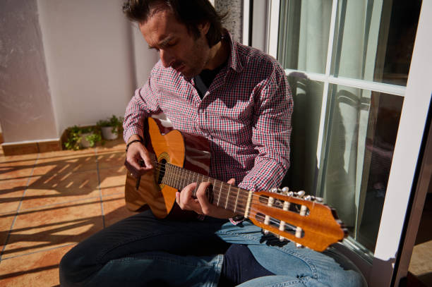 istock Man playing guitar outside on a sunny day 2198707645