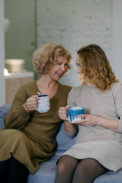 istock Family connection, mother and daughter chatting while holding handmade mugs 2198710106