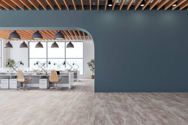 istock Semi-empty office interior with arched prussian blue wall and copy space,  a wooden slats ceiling, work desks and large windows, on wood look tiled floor 2198711313