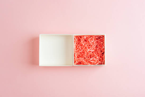 istock Empty white gift box with coral shredded paper on a pink background, symbolizing celebration and creativity. Top view, flat lay 2198711599