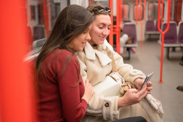 istock Two women using the phone in the subway train 2198711745