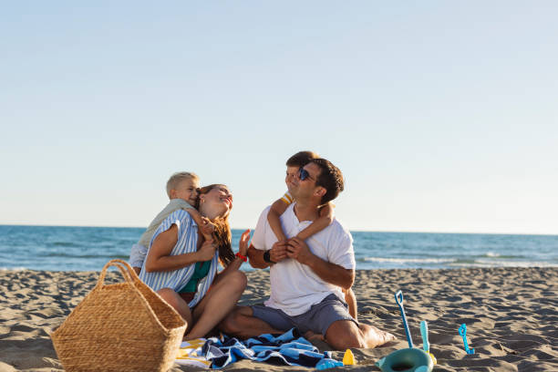 istock Happy family hugging and enjoying beach vacation together 2198712738