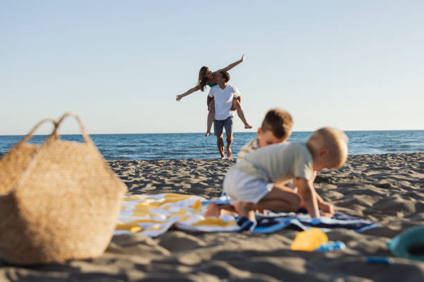 Happy family having fun on the beach during summer vacation