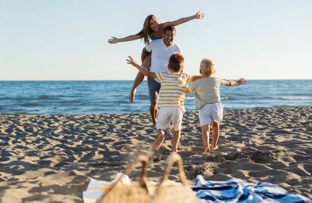 istock Happy family playing and running on the beach 2198713022