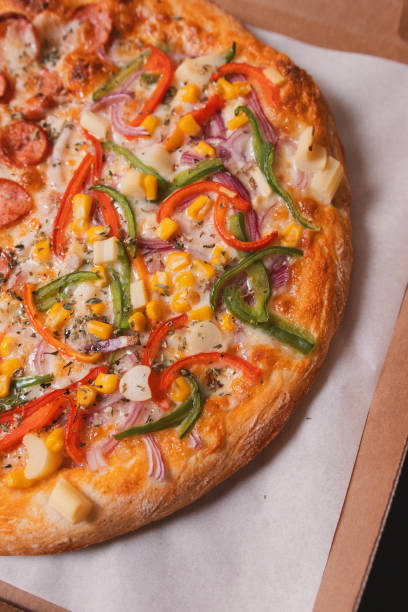 istock Close-up view of a pizza with vegetables, placed in a box. 2198713461