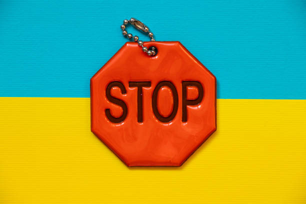 Flag of Ukraine and reflective keychain with text stop as background